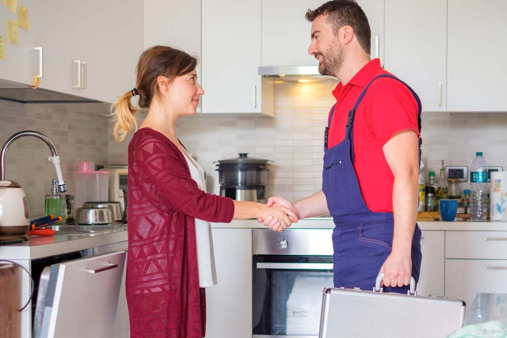 Plumber and homeowner shaking hands
