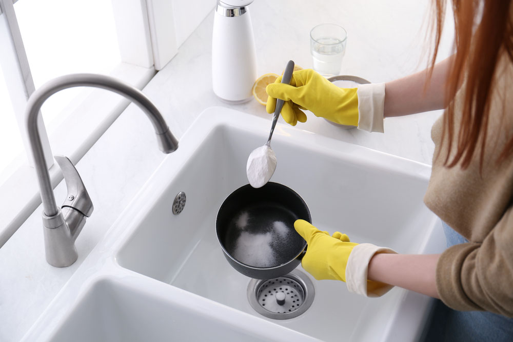 woman pouring baking soda in sink Woodstock, GA